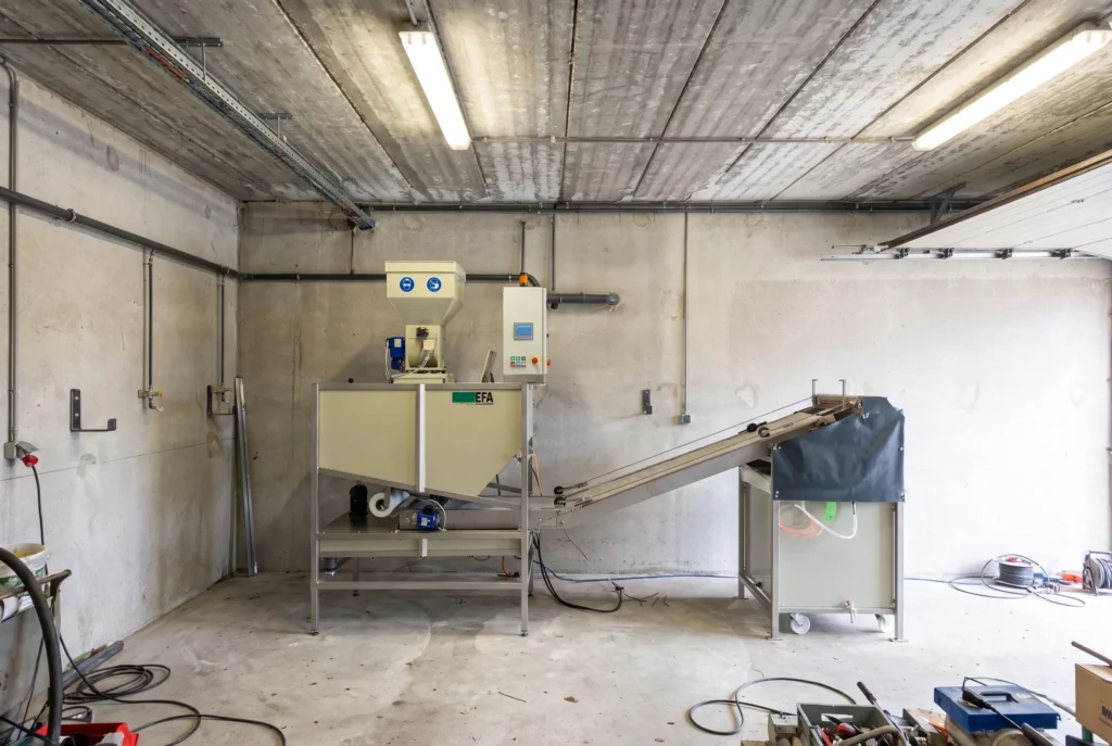 Compacte afvalwaterbehandelingsinstallatie met bandfilter in een betonnen ruimte bij een Belgische schrootplaats